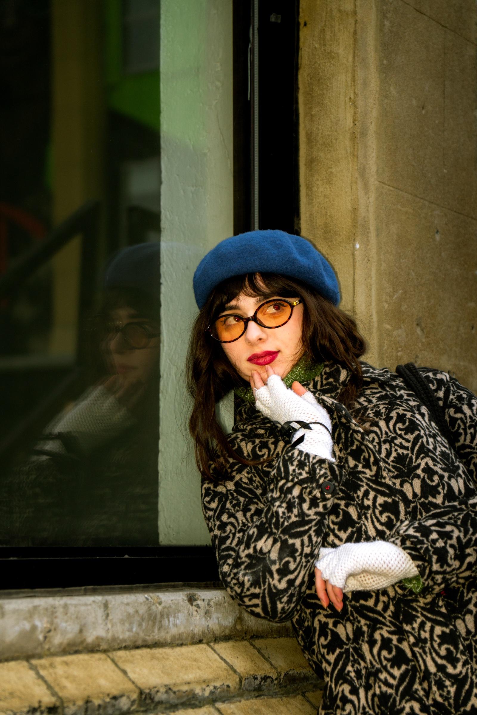 Vintage editorial portrait in blue beret by shop window