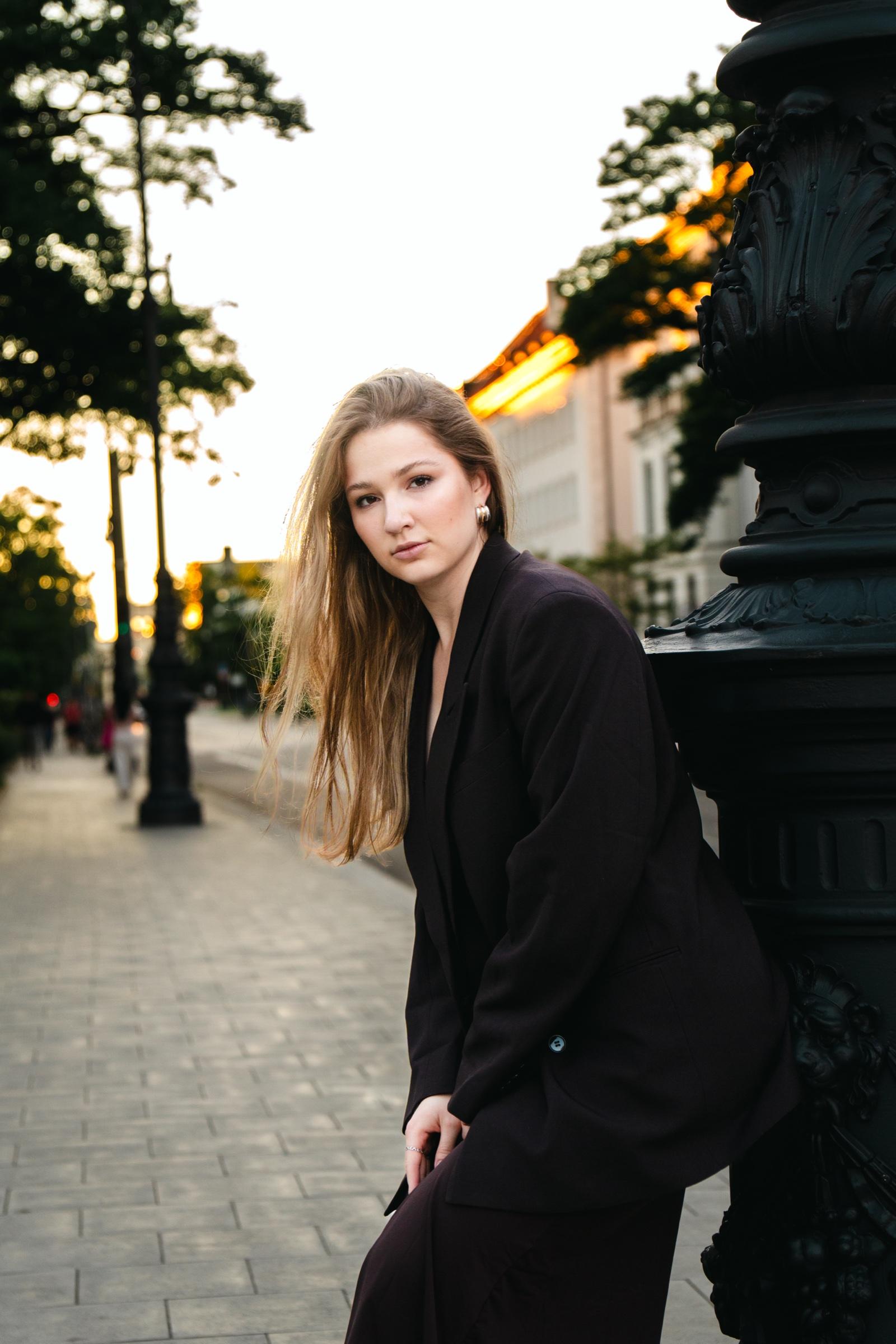 Editorial portrait leaning on lamppost at golden hour