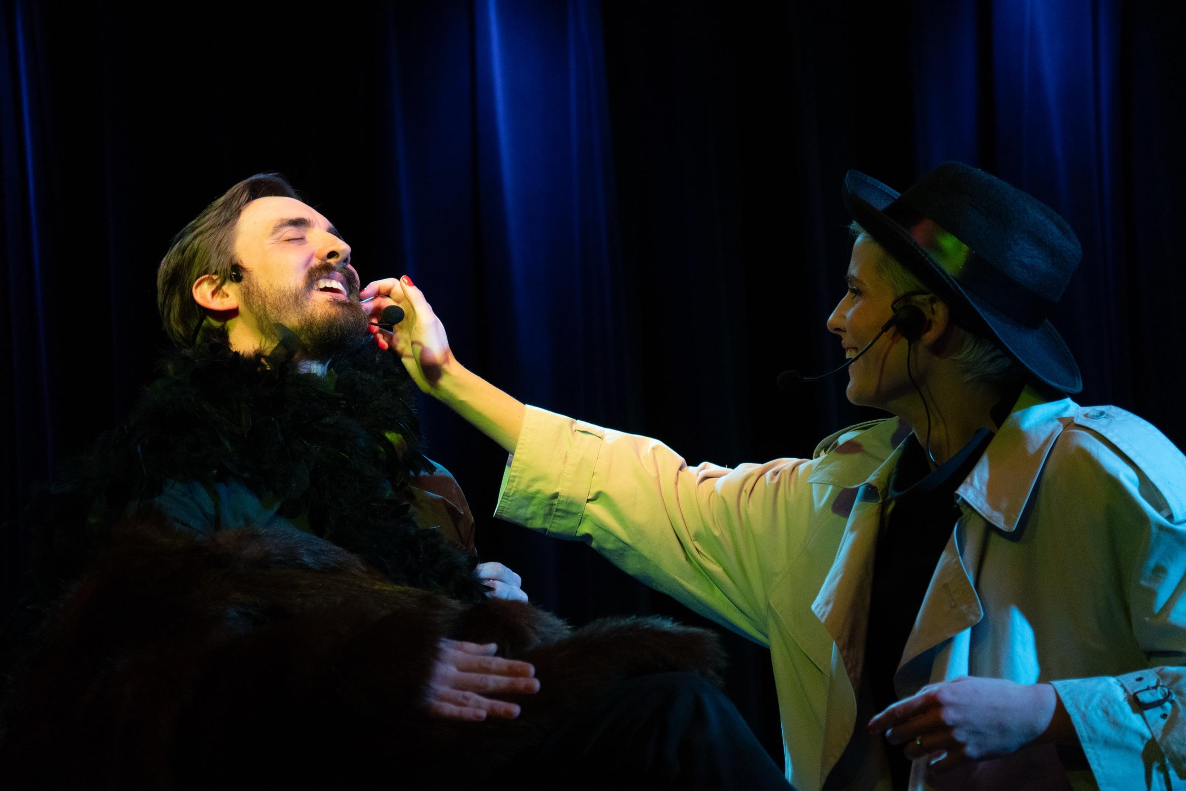 Improvisers sharing a laugh mid-scene on stage
