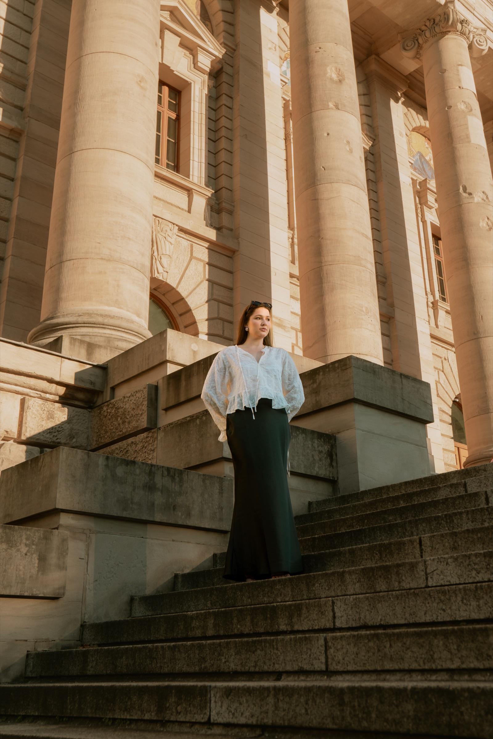 Editorial portrait standing before a columned facade