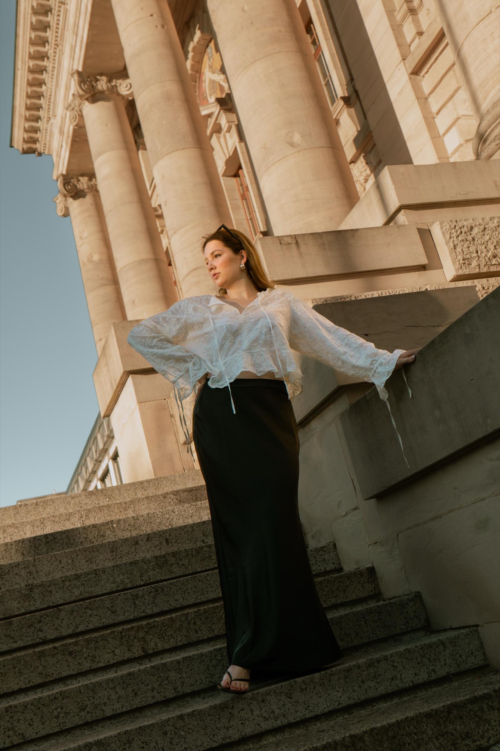 Low-angle editorial portrait descending classical steps