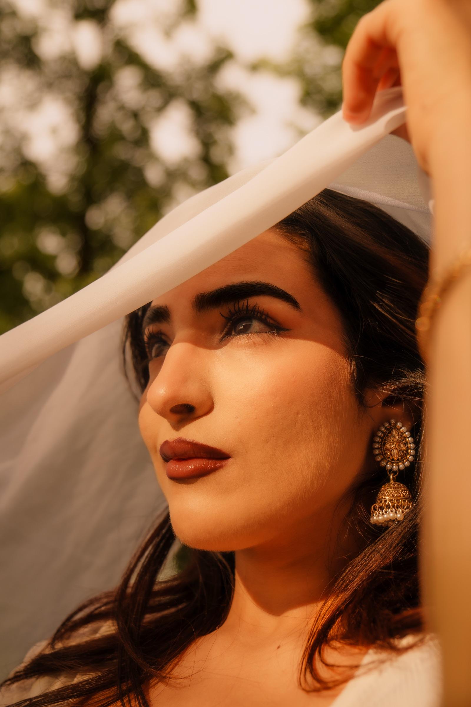 Profile portrait of a woman beneath a sheer flowing veil